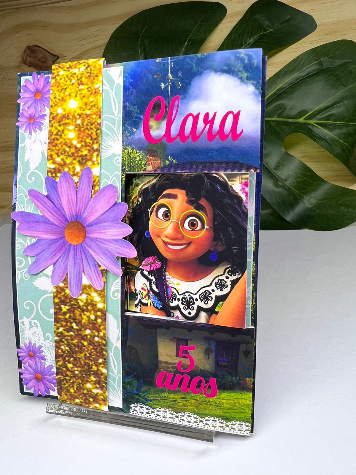 Convite 3D Encanto com flores roxas, camadas de papel e fita dourada