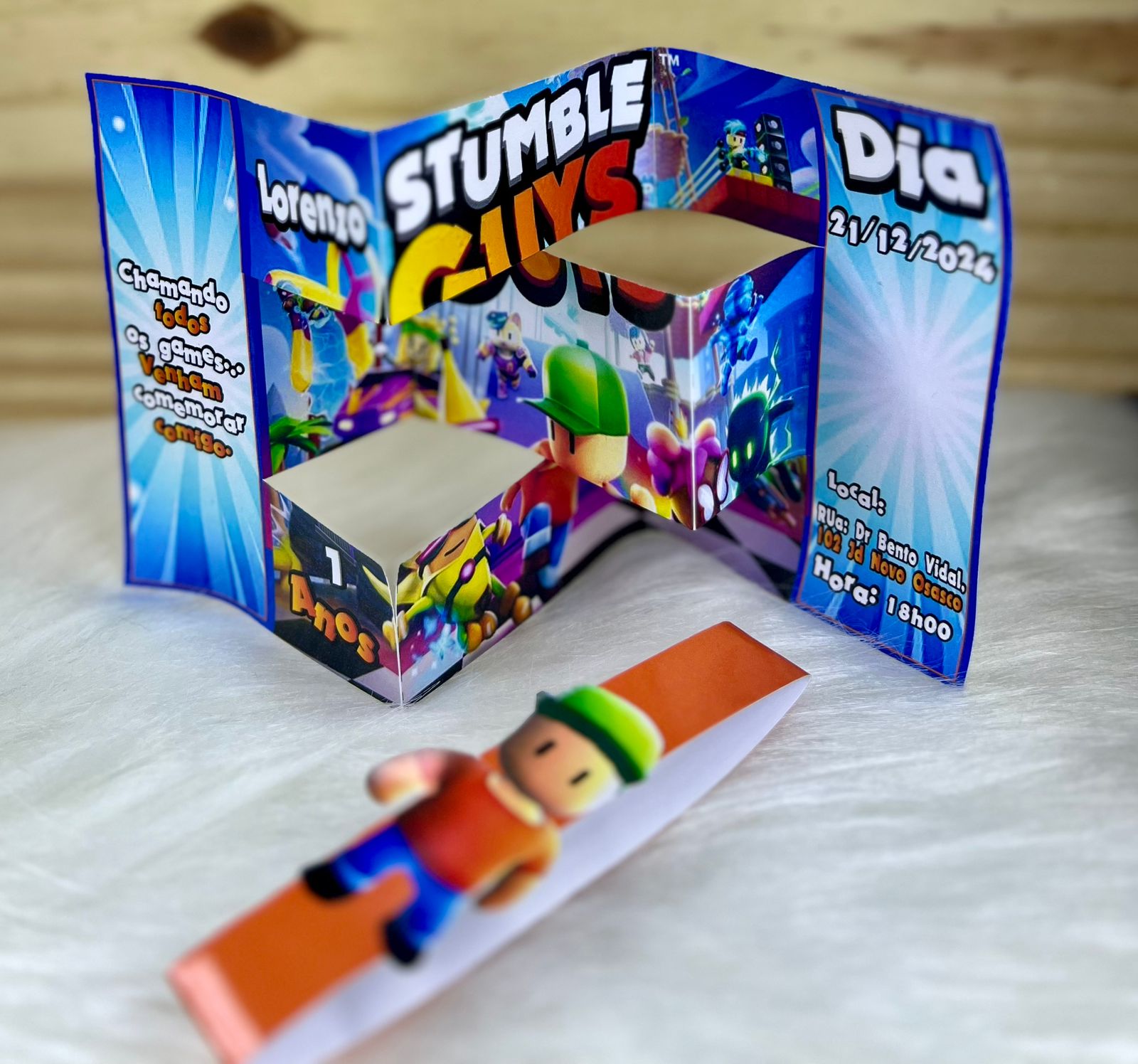 Convite 3D aberto de tema game, em azul com personagens e dados da festa